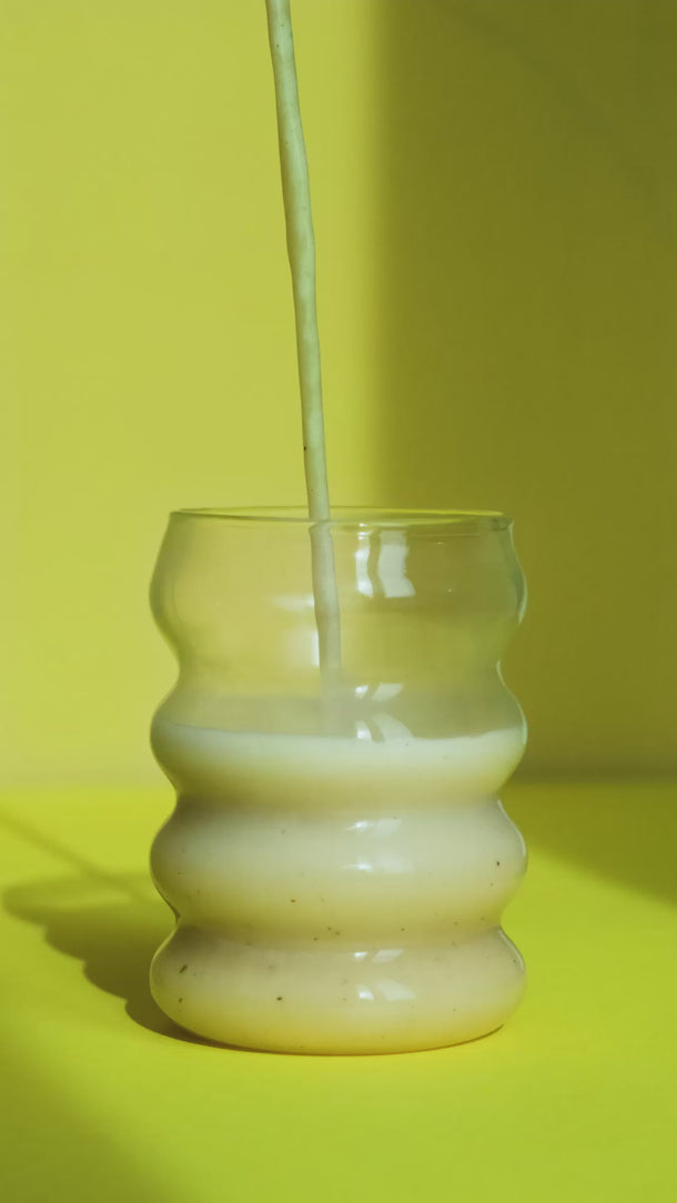 Vanilledrink wird ins Glas gegossen – das Glas füllt sich langsam.