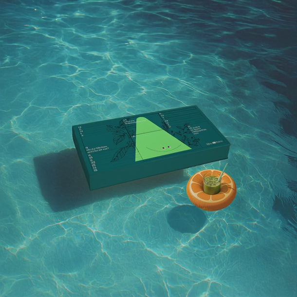 Auf dem Wasser schwimmt der Adventskalender und daneben in einem kleinen Schwimmring der Matcha Latte im Glas